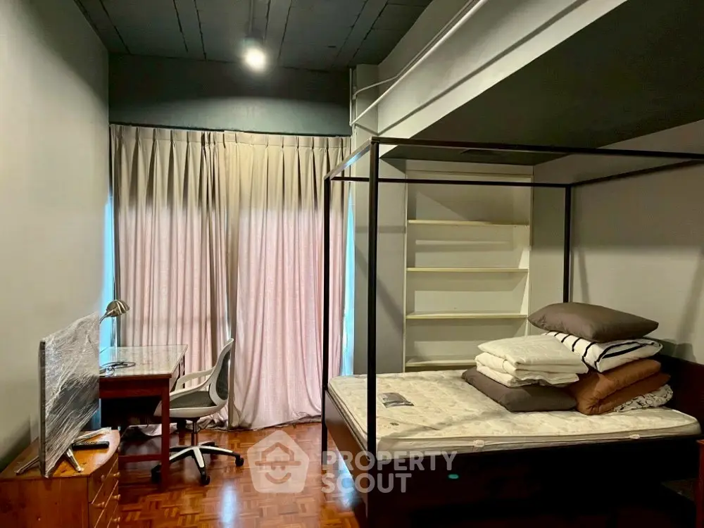 Cozy bedroom with four-poster bed and study desk, ideal for comfort and productivity.