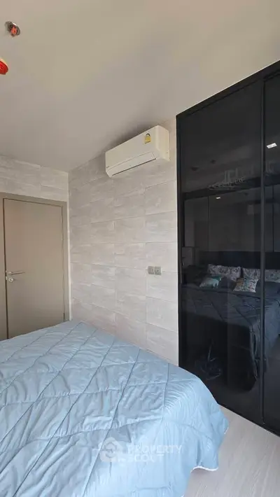 Modern bedroom with sleek design and air conditioning, featuring a cozy bed and stylish decor.
