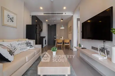 Modern living room with cozy beige sofa, wall-mounted TV, and stylish decor