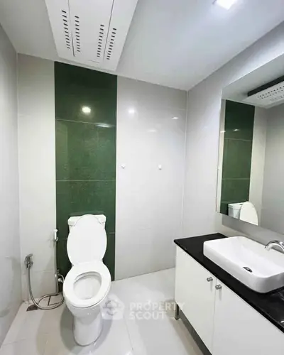 Modern bathroom with sleek design and elegant fixtures, featuring a stylish vanity and contemporary toilet.