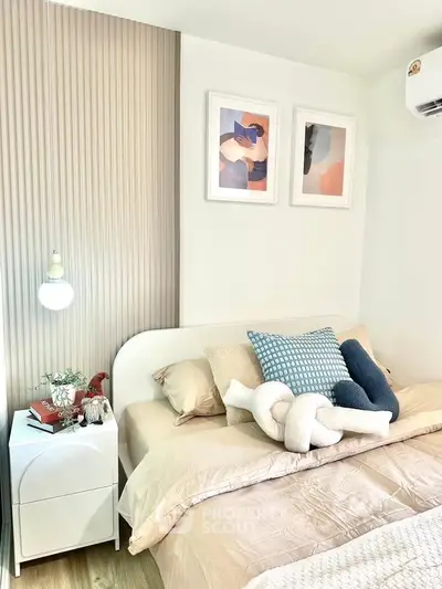 Cozy bedroom with modern decor, featuring stylish artwork and soft lighting for a relaxing ambiance.
