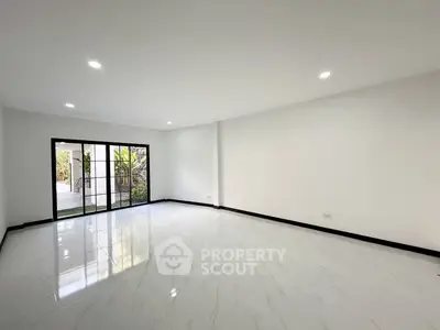 Spacious empty living room with large windows and glossy white flooring