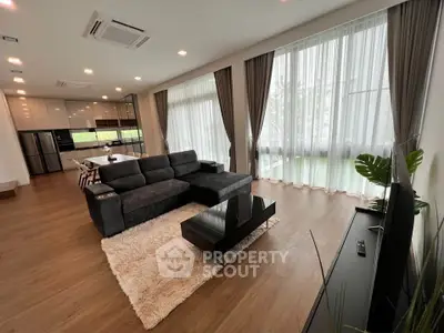 Spacious modern living room with large windows and open kitchen layout