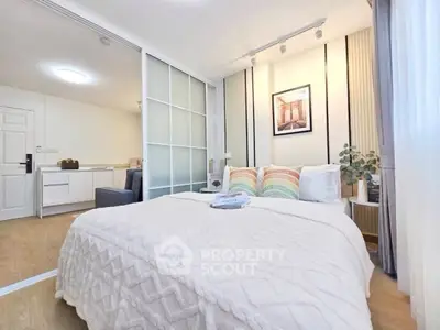 Cozy bedroom with modern decor and sliding glass doors in stylish apartment.