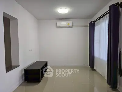 Minimalist living room with air conditioning and sleek tile flooring.