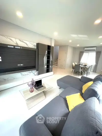 Modern living room with sleek furniture and open dining area