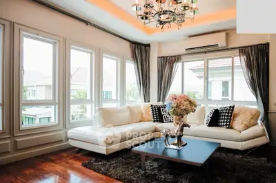 Luxurious living room with elegant decor and large windows offering natural light.