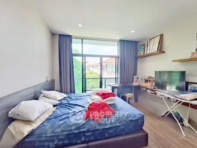 Spacious bedroom with large window and modern decor
