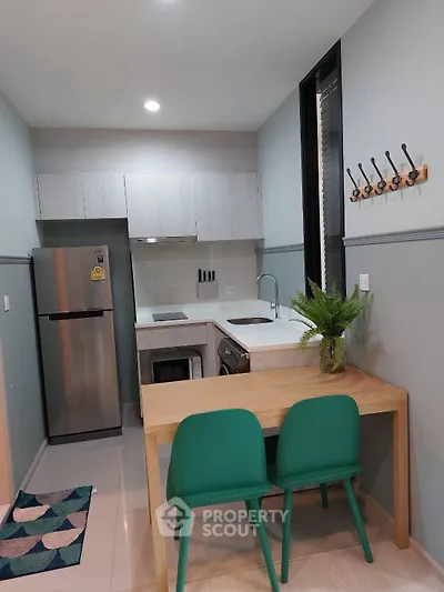 Modern compact kitchen with sleek appliances and stylish dining area