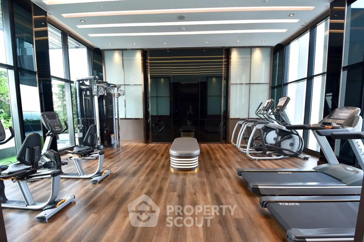 Luxurious modern gym with state-of-the-art equipment and sleek design in a high-end residential building.