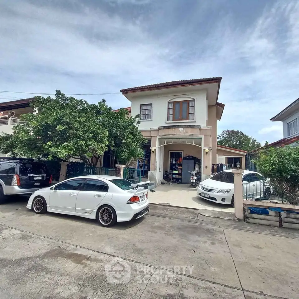 Charming two-story house with driveway and lush greenery in suburban neighborhood.
