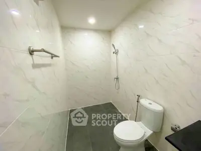 Modern minimalist bathroom with sleek white tiles and shower area