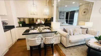 Chic open-layout kitchen and living room with elegant decor and cozy seating area.