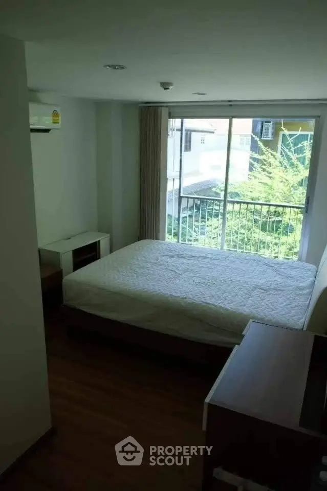 Cozy bedroom with large window and lush green view, perfect for relaxation and comfort.