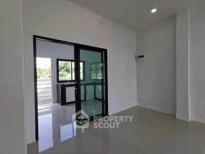 Spacious modern interior with sliding glass doors leading to a bright balcony view.