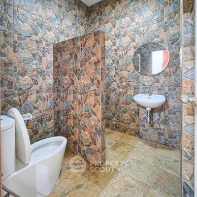 Modern bathroom with stone tile walls and sleek fixtures