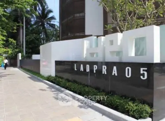 Modern building entrance with sleek design and lush greenery