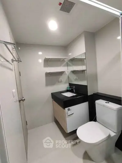 Modern bathroom with sleek fixtures and minimalist design, featuring a spacious vanity and contemporary lighting.
