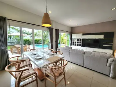 Spacious living room with pool view, modern furniture, and elegant dining area.