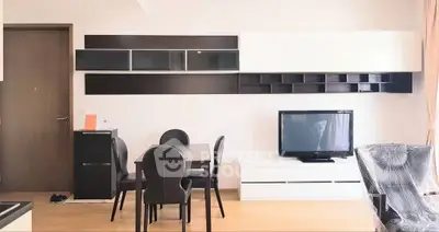 Modern living room with sleek furniture and wall-mounted storage in a bright apartment.