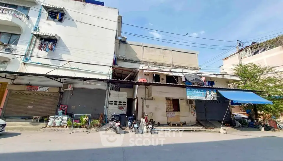 Street view of mixed-use building with shops and residential units, showcasing urban living and commercial potential.