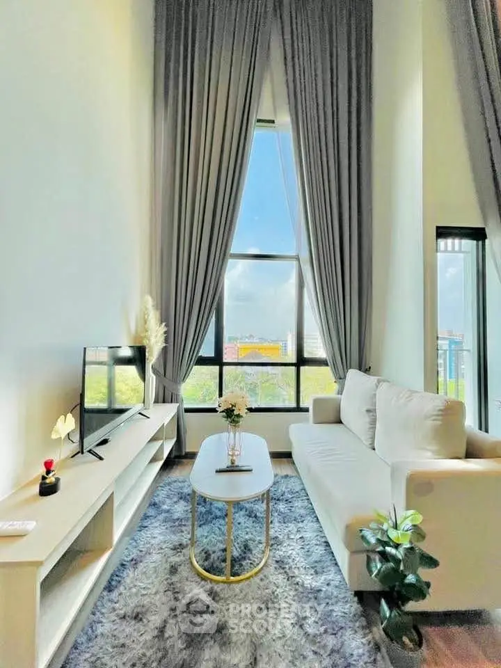 Bright and airy living room with high ceilings and large windows offering a stunning view.