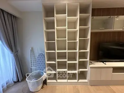 Modern living room with stylish shelving unit and TV stand, featuring elegant wooden flooring and natural light.