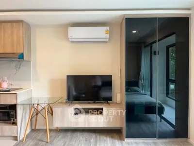 Modern living room with sleek furniture and air conditioning, featuring a glass dining table and wall-mounted TV.