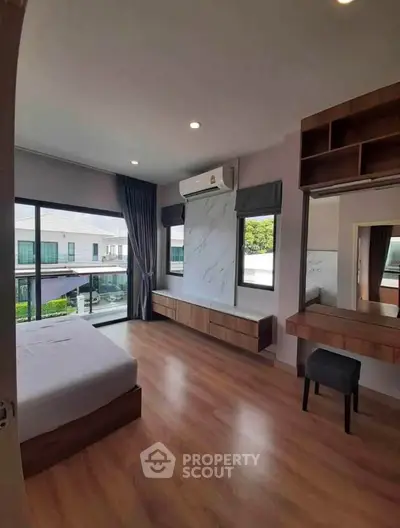 Spacious modern bedroom with large windows and elegant wooden flooring
