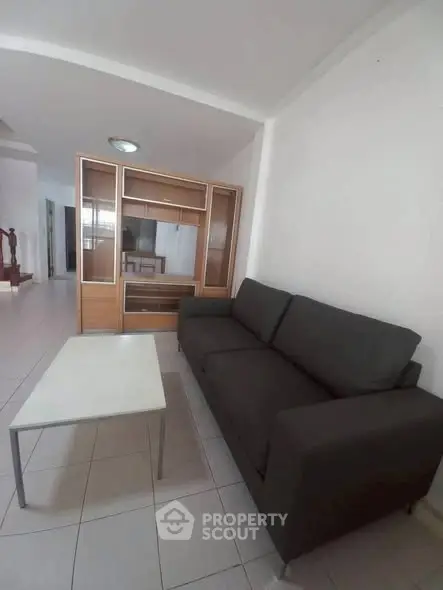 Spacious living room with modern sofa and sleek coffee table in a bright apartment.