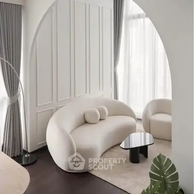 Elegant modern living room with curved sofa, large windows, and stylish decor.