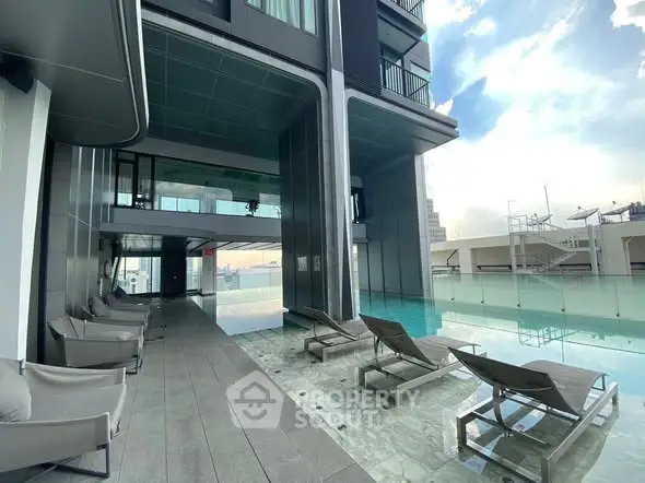Luxurious rooftop pool with modern lounge chairs and stunning city views.