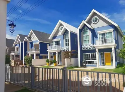 Charming blue townhouses with modern design and spacious balconies in a serene neighborhood.