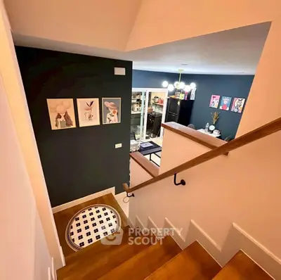 Stylish staircase leading to a modern living room with chic decor and artwork.
