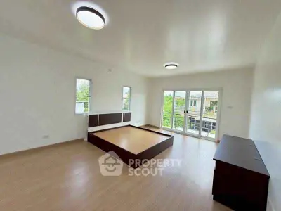 Spacious bedroom with large windows and modern lighting in a bright home.