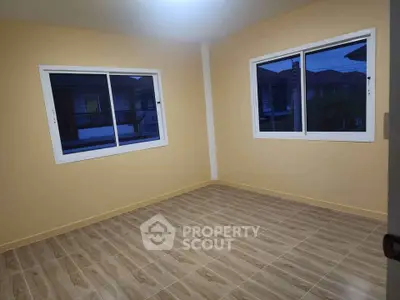 Spacious empty room with large windows and tiled flooring, perfect for customization.