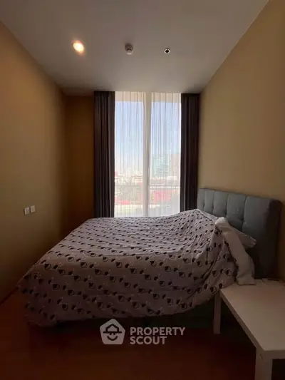 Cozy bedroom with large window and modern decor in urban apartment