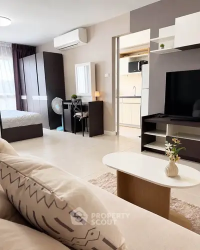 Modern studio apartment with open layout, featuring cozy living area and stylish bedroom.