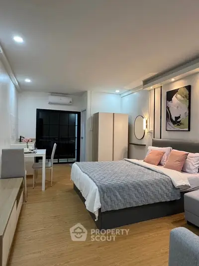 Modern studio apartment with cozy bedroom and stylish decor, featuring a comfortable bed and elegant lighting.