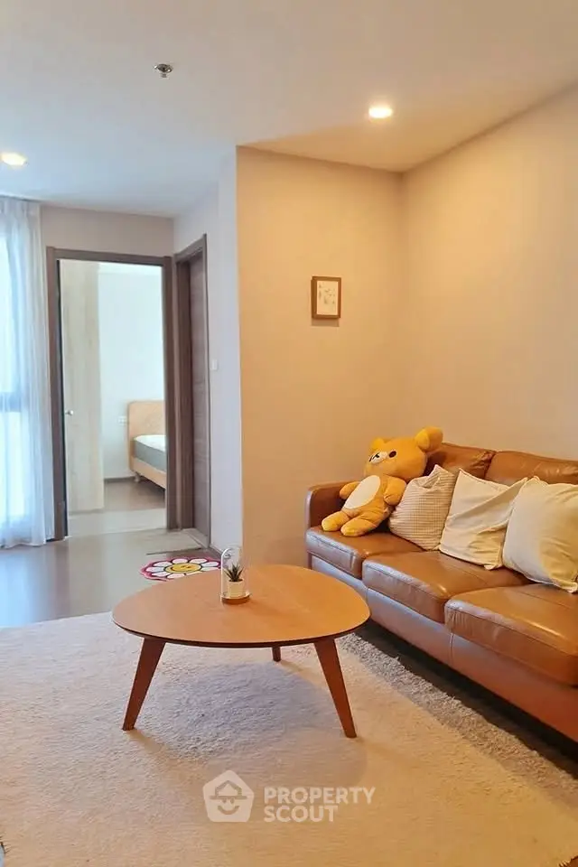 Cozy living room with brown leather sofa and plush toy, perfect for relaxation.