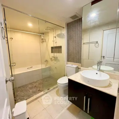 Modern bathroom with glass shower and sleek fixtures in a contemporary apartment.