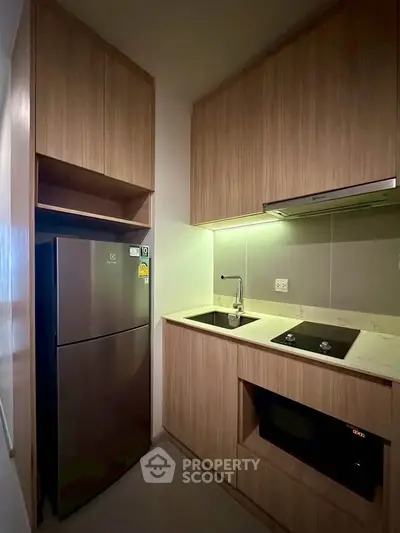 Modern compact kitchen with sleek appliances and wooden cabinetry