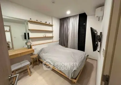 Cozy modern bedroom with stylish decor and wall-mounted TV, perfect for relaxation.