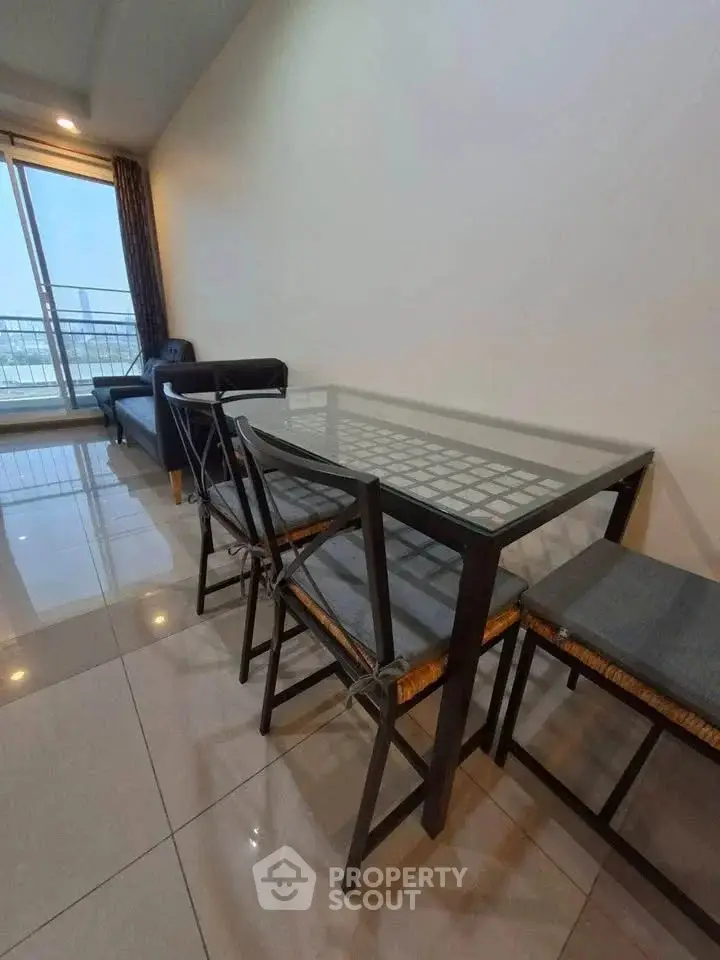 Modern living room with glass dining table and balcony view