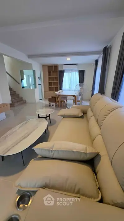 Spacious modern living room with plush sofa and elegant decor, perfect for relaxation and entertainment.