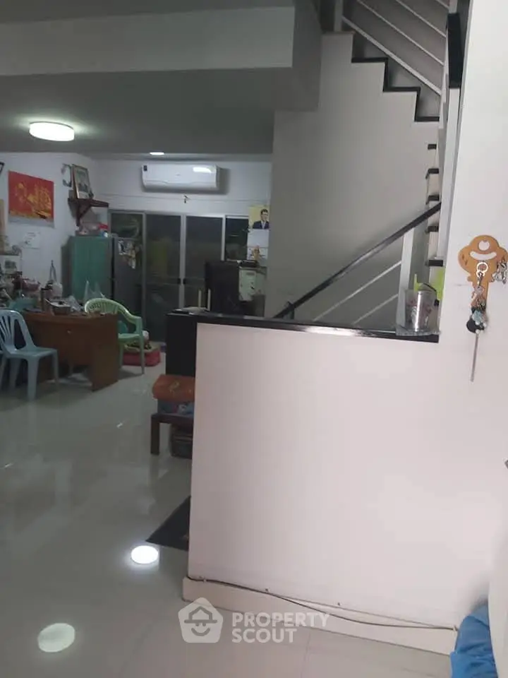 Spacious living area with modern staircase and sleek interior design.