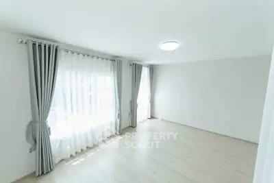 Spacious empty room with large windows and elegant curtains, perfect for customization.