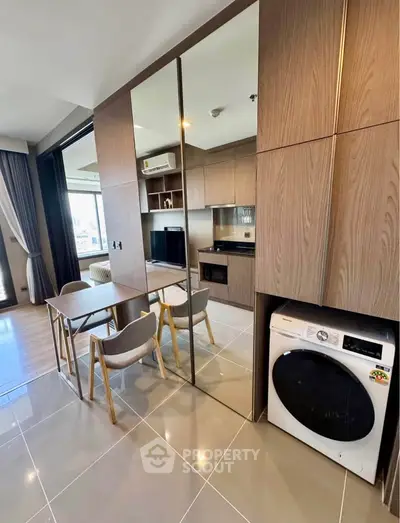 Modern apartment interior with open kitchen, dining area, and built-in washing machine.
