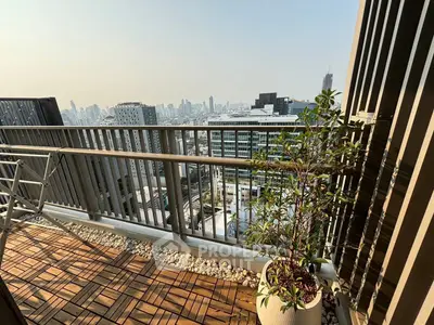 Stunning city view from a modern balcony with wooden flooring and potted plant.