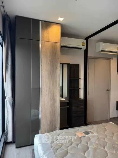 Modern bedroom with sleek wardrobe and air conditioning in a stylish apartment.